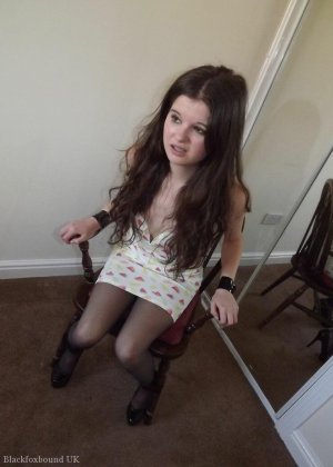 Одетая девушка Тамара смотрит в зеркало с кляпом во рту и привязана к стулу