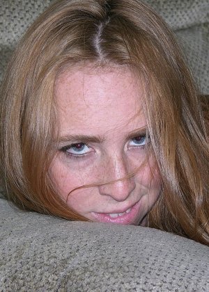 Новичок Ливия машет рукой после того, как раздевается на тканевом диване